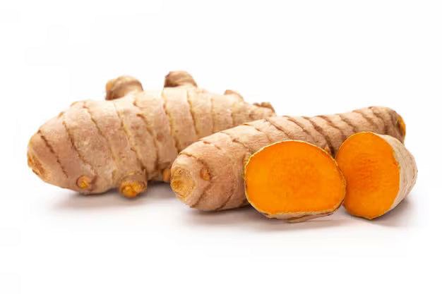 fresh turmeric root and ground powder wooden surface close up