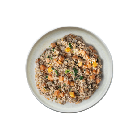 A white bowl filled with diced sweet potatoes, ground salmon, and herbs on a black background. The dish is filled with NutriCanine fresh cooked Salmon Recipe. It looks rustic and hearty, evoking a cozy, comfort-food vibe.