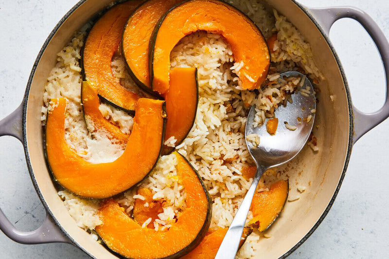 Roasted squash and white rice cooking together in a pot, representing digestible carbohydrates in dog food